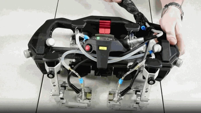 Vista superior detallada del escáner AxSEAM mostrando la disposición de sus soportes pivotantes, mangueras de acoplante y el módulo ScanDeck iluminado. Un operador ajusta el equipo manualmente, demostrando la rápida configuración sin herramientas para la inspección de soldaduras de tuberías.